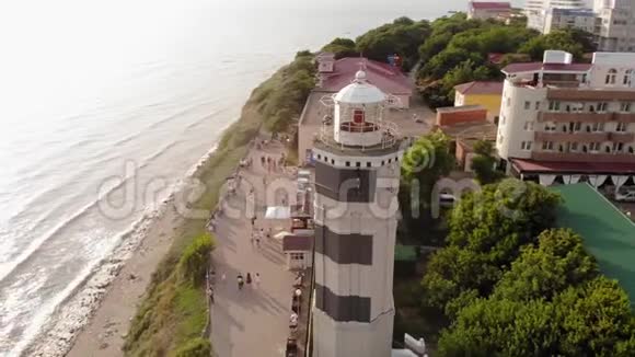 飞过靠近大海的海岸悬崖上的灯塔空中射击视频的预览图