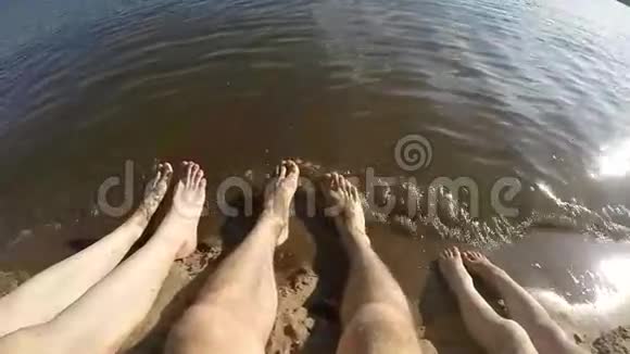年轻幸福的一家人坐在海滩上视频的预览图