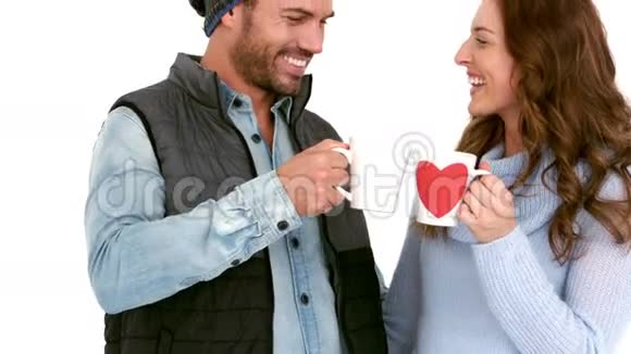 可爱的年轻夫妇穿着暖和的衣服拿着杯子视频的预览图