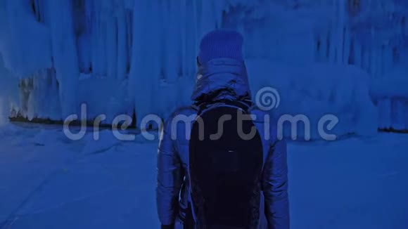 在贝加尔湖冰洞旅行的女人去冬岛旅行女孩背包客正在冰窟散步旅行者看起来视频的预览图