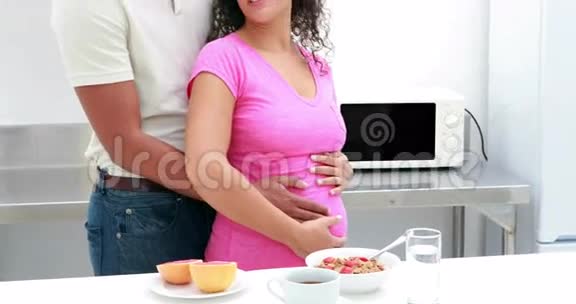 一对怀孕夫妇手臂环抱的肖像视频的预览图