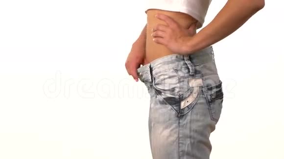 穿大牛仔裤的苗条女孩展示她的减肥视频的预览图