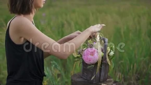 穿着黑色裙子的苗条女孩在日落时的花朵作品视频的预览图