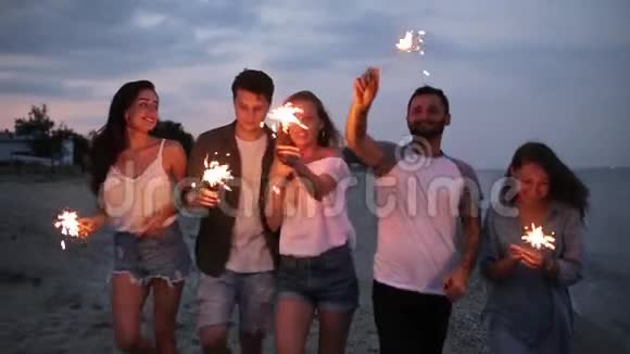 朋友们在海边的夜晚聚会上散步跳舞玩得开心手里拿着孟加拉的闪亮灯视频的预览图