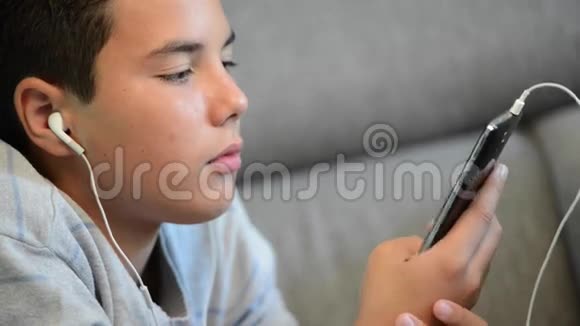 少年躺在手机里听音乐视频的预览图