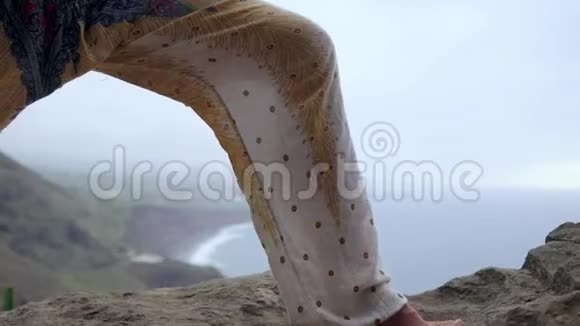 日落时在岩石海岸做瑜伽的年轻女子健康生活方式的概念和谐人性与自然这就是视频的预览图