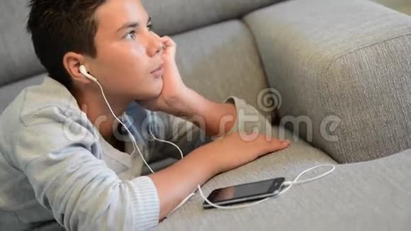 少年躺在手机里听音乐视频的预览图