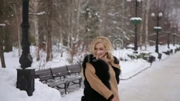 嘲笑年轻女子在冬季公园玩得开心视频的预览图