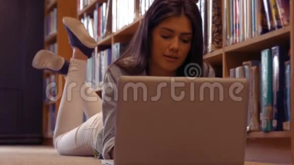 安静的学生在图书馆里使用笔记本电脑视频的预览图