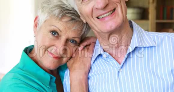 一对笑容可掬的老夫妇在客厅合影留念视频的预览图