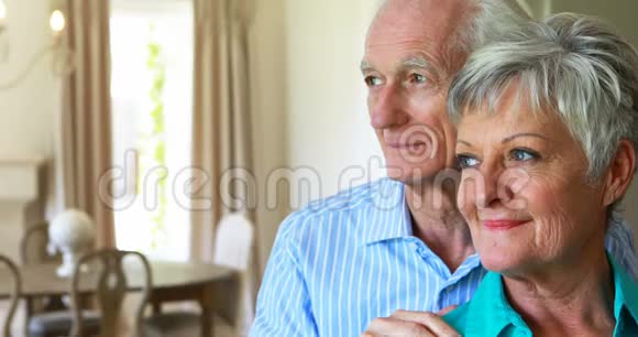 一对笑容可掬的老夫妇在客厅合影留念视频的预览图