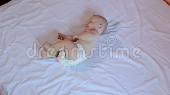一个可爱的新生婴儿躺在卧室的床上肖像视频的预览图