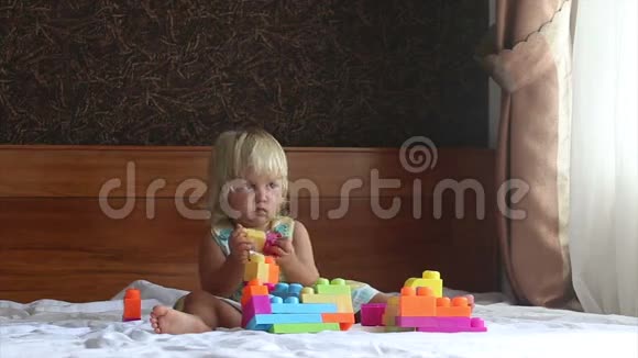 小金发女孩在沙发上玩玩具构造器视频的预览图
