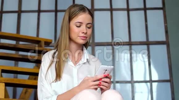 年轻女孩使用手机浏览社交网络或在线信息视频的预览图