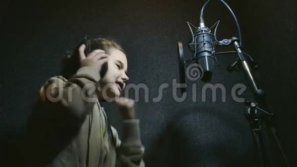 少女耳机唱入麦克风音频专业录音室音乐视频的预览图