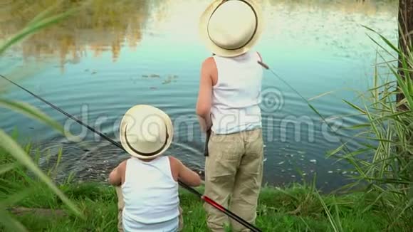 孩子们在池塘边钓鱼两个小孩在达查的池塘里钓鱼视频的预览图