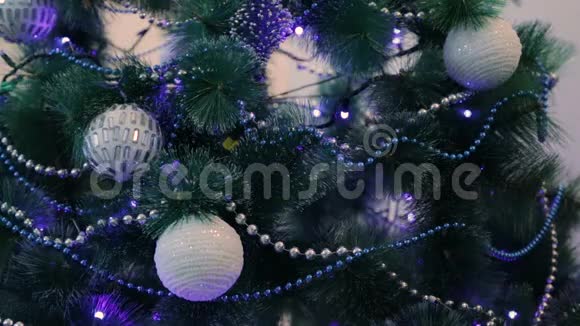 用蓝灯装饰的圣诞树白色圣诞球和花环视频的预览图