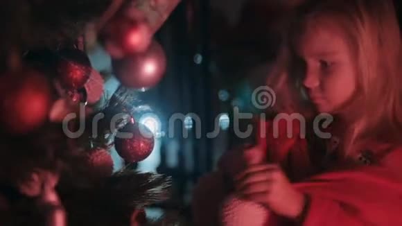 美丽的小女孩挂在圣诞树上视频的预览图