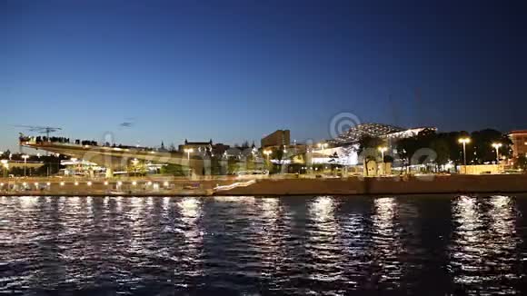 莫斯克瓦河Moskvoretskaya河岸Zaryadye公园浮桥和夜间旅游观光船莫斯科俄罗斯视频的预览图