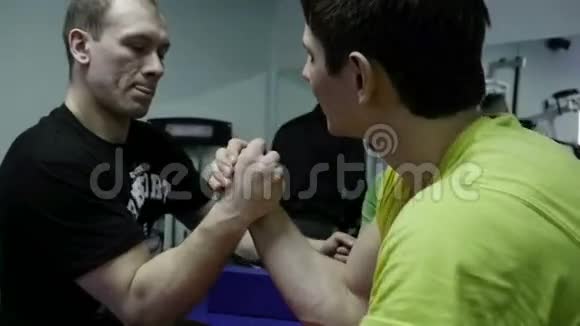 在健身房练习手臂摔跤的男人视频的预览图