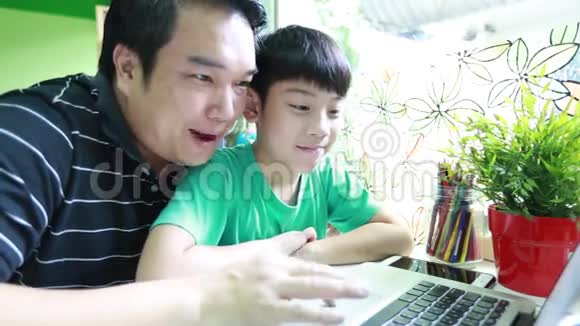 快乐的亚洲父子正在上网视频的预览图