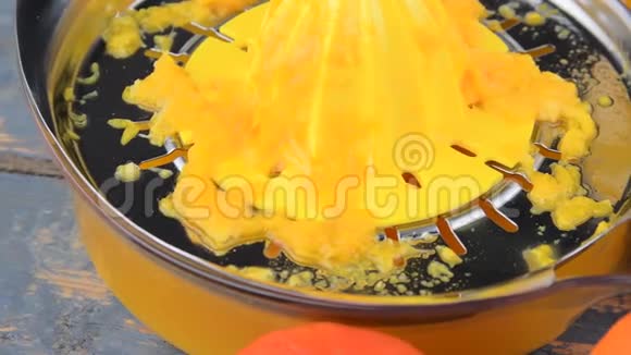 橘子橘子一杯橙汁和手动柑橘吱吱在蓝色的木制背景橘子切成两半视频的预览图