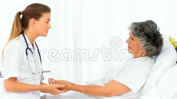 一位美丽的护士在家给她的病人做脉搏视频的预览图