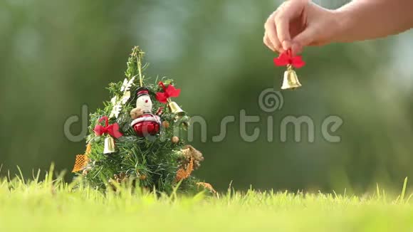 女孩把铃铛挂在圣诞树上视频的预览图