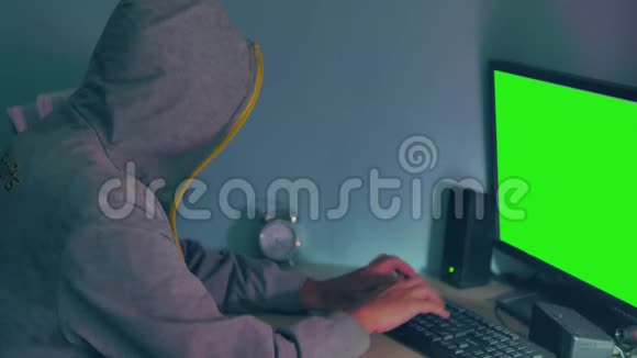 男性黑客在电脑上工作一个黑客隐藏了他的室内面孔视频的预览图
