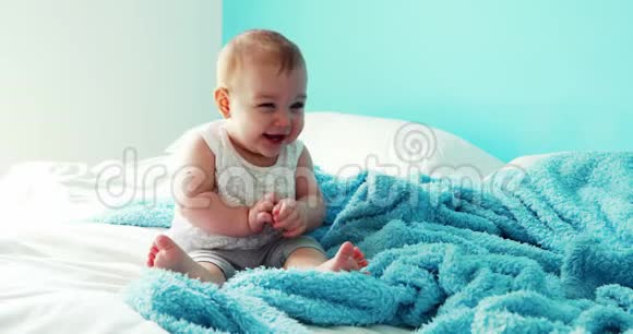 坐在床上嬉戏的女婴视频的预览图
