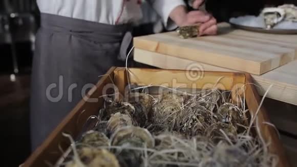 一家豪华鱼餐厅的厨师在桌上打开牡蛎把它们放在一个加冰的盘子里视频的预览图
