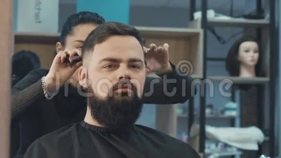 理发店里剪雄性头发的女理发师视频的预览图
