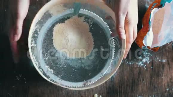 妇女在盘子里筛面粉的俯视图视频的预览图