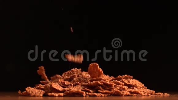 谷物薄片倒在黑色背景上视频的预览图