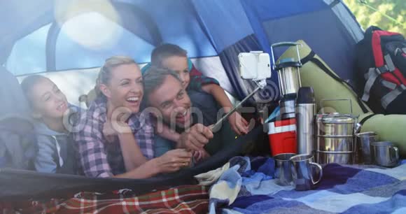 微笑的家人在帐篷里自拍视频的预览图