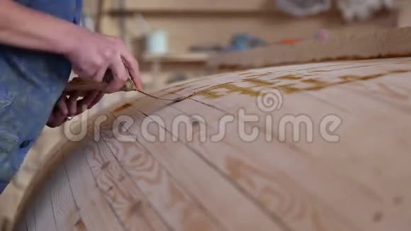 木匠在木船的缝上涂上树脂视频的预览图