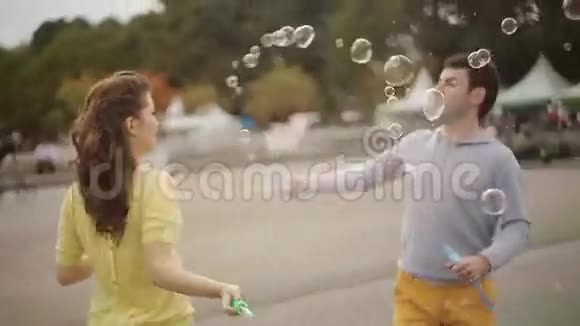 年轻夫妇在公园玩肥皂泡视频的预览图