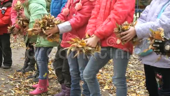 孩子们手里握着黄色的树叶视频的预览图