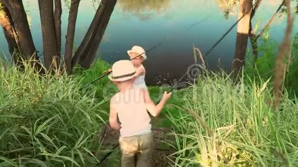 孩子们在池塘边钓鱼夏日里美丽的湖视频的预览图
