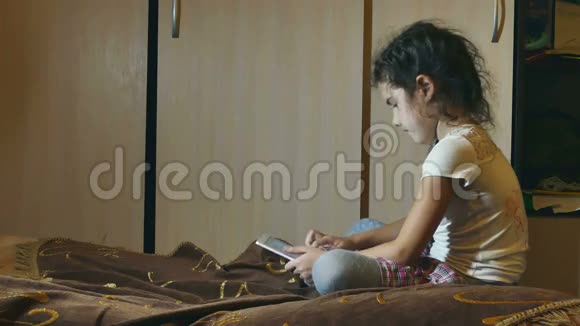 在房间里看平板电脑的女孩在网上看互联网视频的预览图