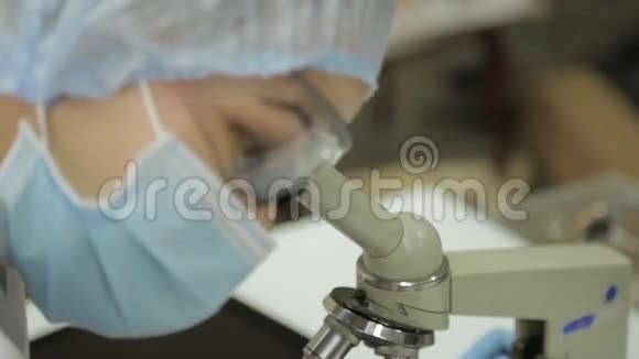 女性医学研究人员在实验室条件下使用显微镜和试管进行调查和采集视频的预览图