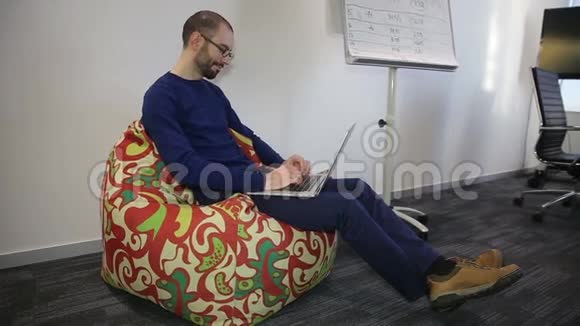 戴眼镜的人在笔记本电脑上工作视频的预览图