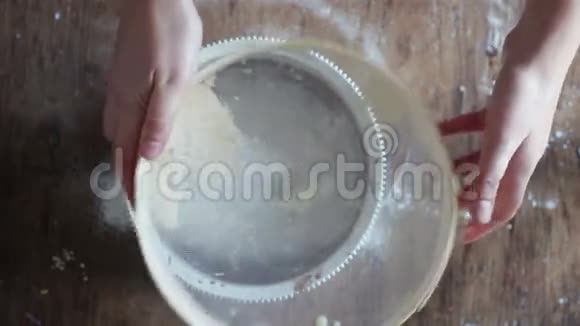 妇女在盘子里筛面粉的俯视图视频的预览图