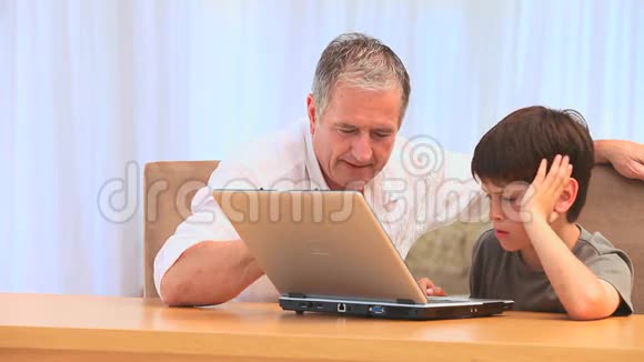 爷爷和孙子一起用笔记本电脑视频的预览图