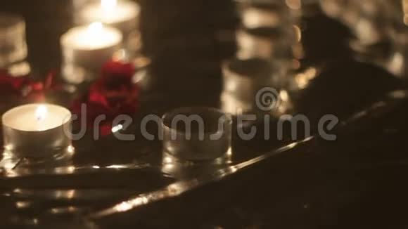 蜡烛旁边的玫瑰花瓣特写全景视频的预览图