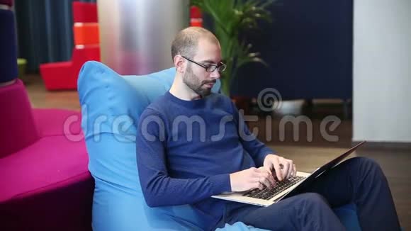 戴眼镜的人在笔记本电脑上工作视频的预览图