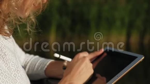 女人在户外使用电脑平板电脑视频的预览图