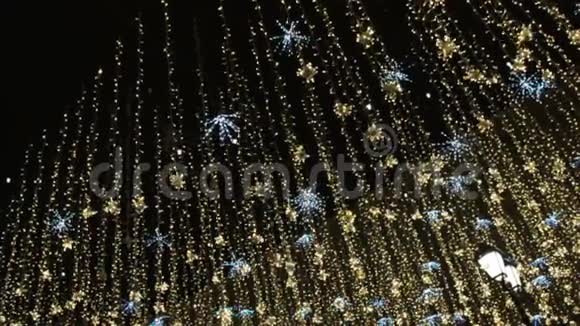 圣诞节和新年假期照明户外城市街道在夜间金光闪闪的花环视频的预览图