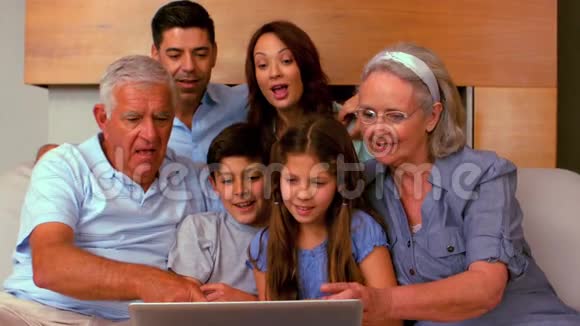 大家庭在沙发上一起使用笔记本电脑视频的预览图