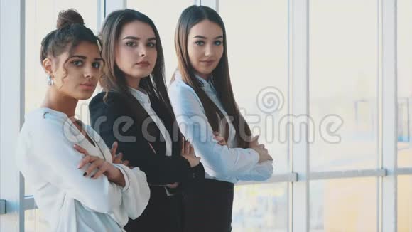 三个商务妇女高兴地交叉双臂看着摄像机视频的预览图